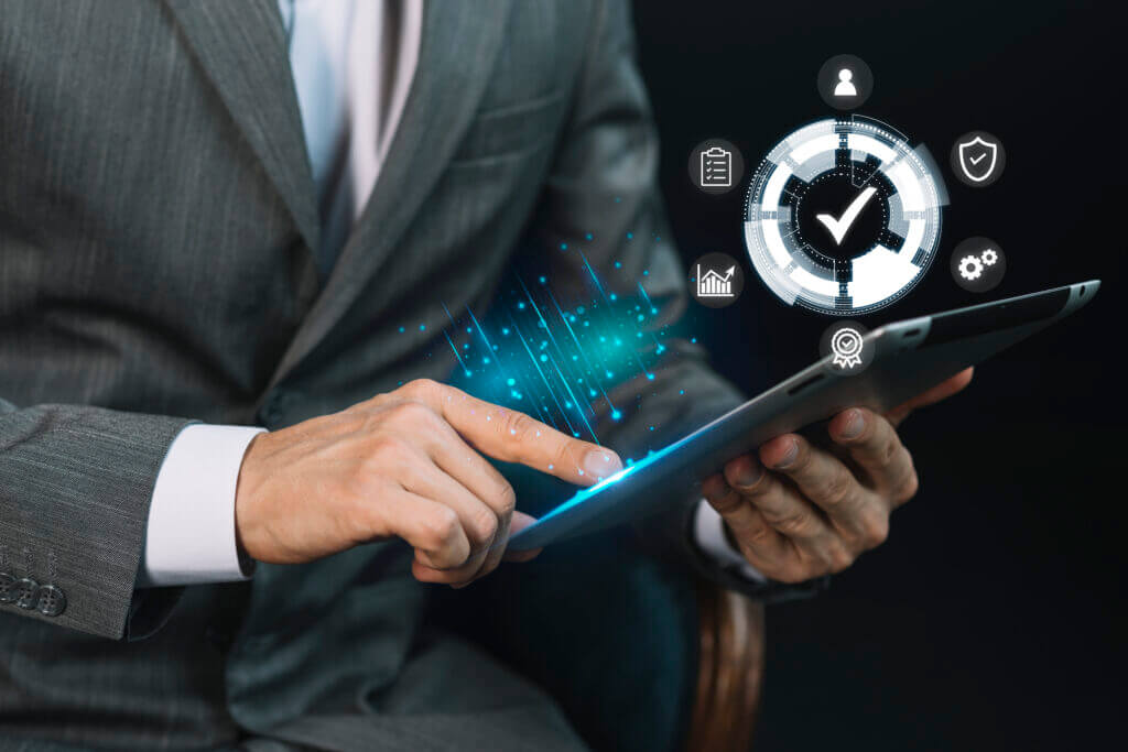 Professional in business attire interacting with a tablet displaying holographic icons of analytics and reporting tools, symbolizing advanced digital reporting and analytics capabilities