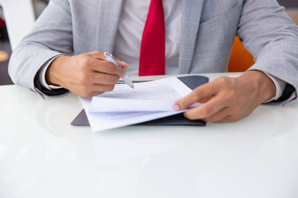 Close-up of professional hands writing on paper, indicating meticulous work in revenue cycle analytics.