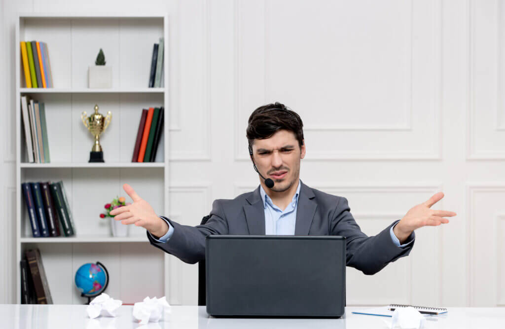 A professional at a desk with an open laptop, gesturing as if explaining or presenting something, symbolizing the process of denial management and appeals in healthcare services